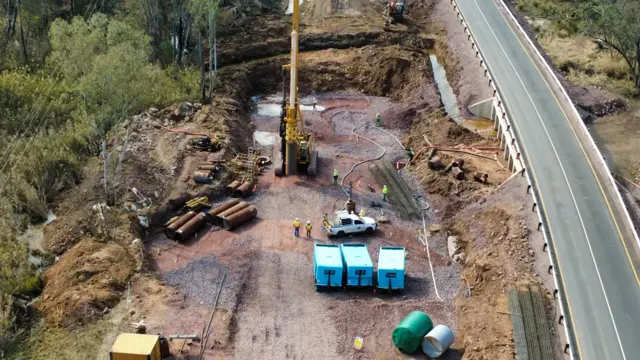 Drone view: piling rig at a bridge site beside a live road