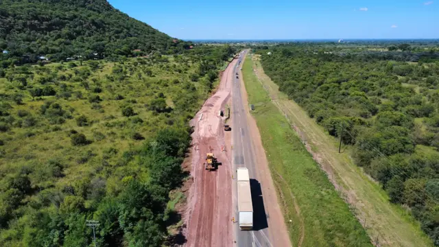 Drone view: culvert works on a road below a mountain