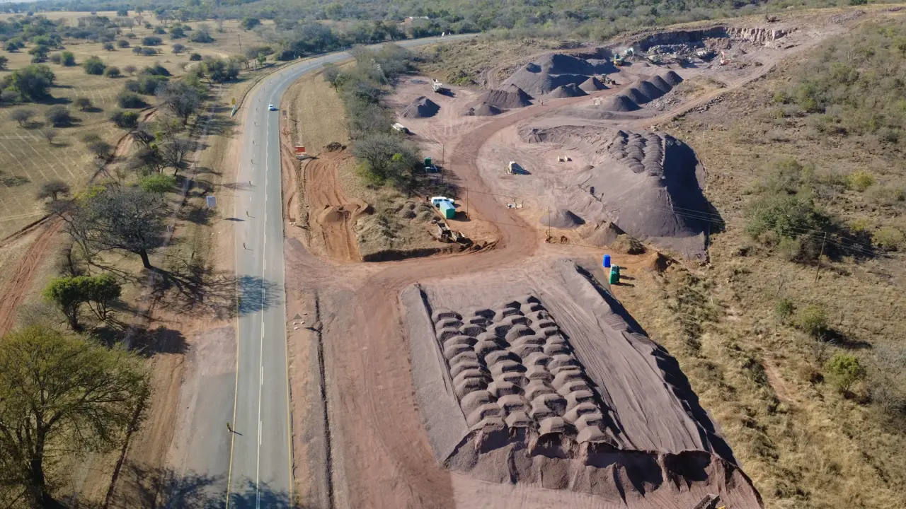 Drone view of material stockpiles beside a road under construction